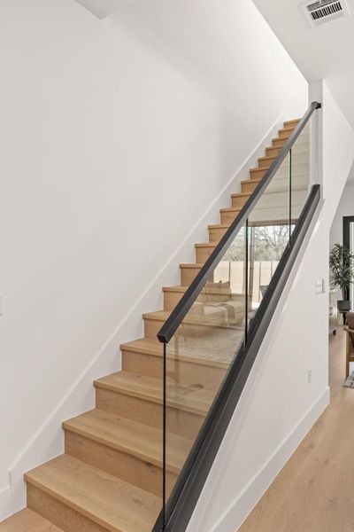 Stairway with wood finished floors and baseboards