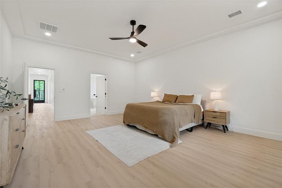 Spacious room featuring light wood-finish flooring, recessed lighting, crown molding, and a ceiling fan