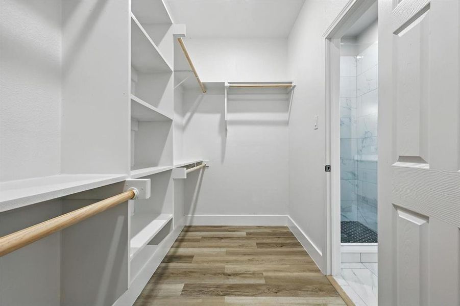Spacious closet with light wood-style floors Spacious closet with light wood-style floors