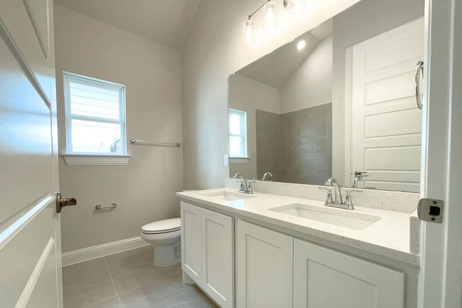 A well-appointed bathroom with a dual vanity and contemporary finishes awaits.