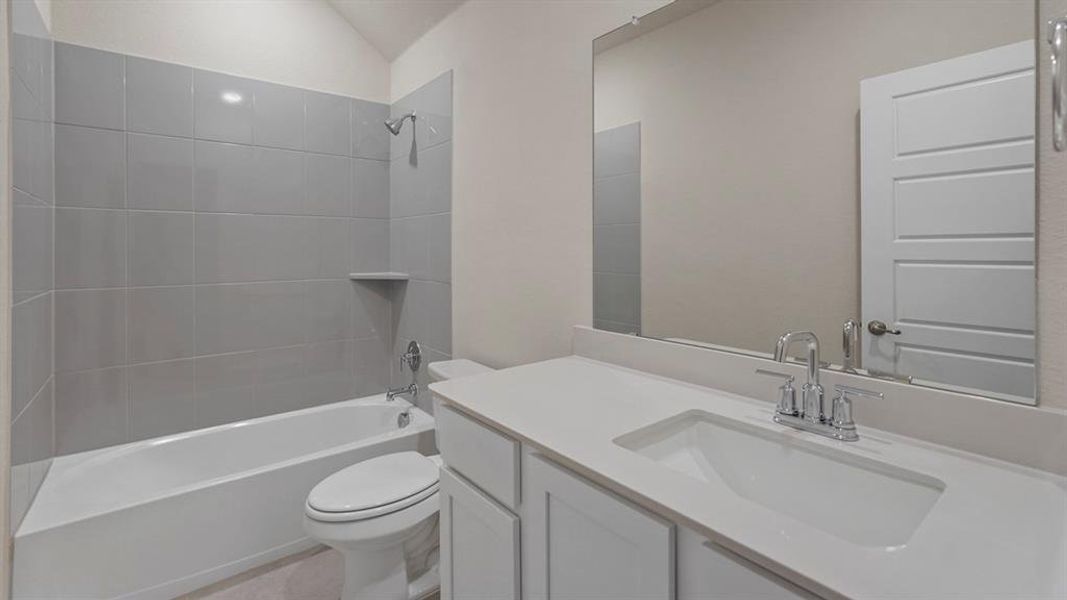 Bathroom featuring a white vanity with an integrated sink, polished chrome faucet, and expansive mirror