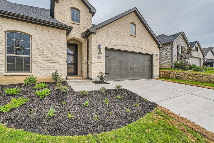 French country inspired facade featuring a garage