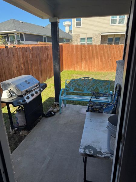 Fenced backyard with a patio and area for grilling