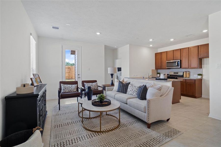 Gather the family and guests together in your lovely family room! Featuring high ceilings, recessed lighting, custom paint, gorgeous tile floors, and a large window that provides plenty of natural lighting throughout the day!