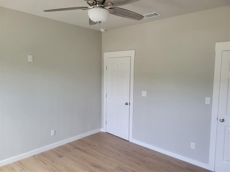 Room featuring light wood-finish flooring, light gray walls, and white baseboards
