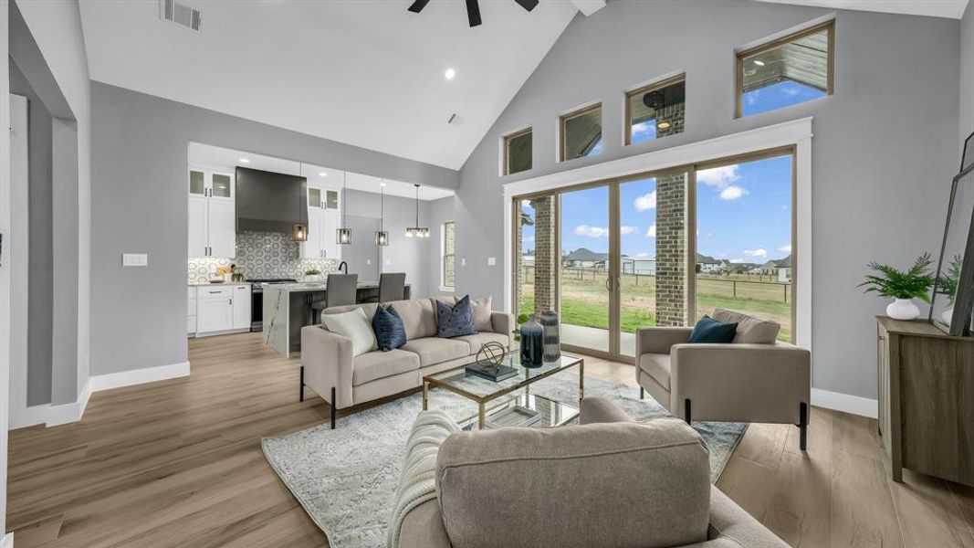 Living area with high vaulted ceiling, light wood-style flooring, ceiling fan, and recessed lighting
