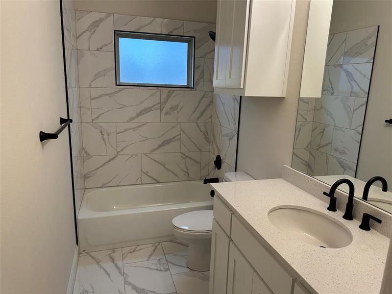 Full bath with toilet, tile flooring, shower / tub combination, and vanity.