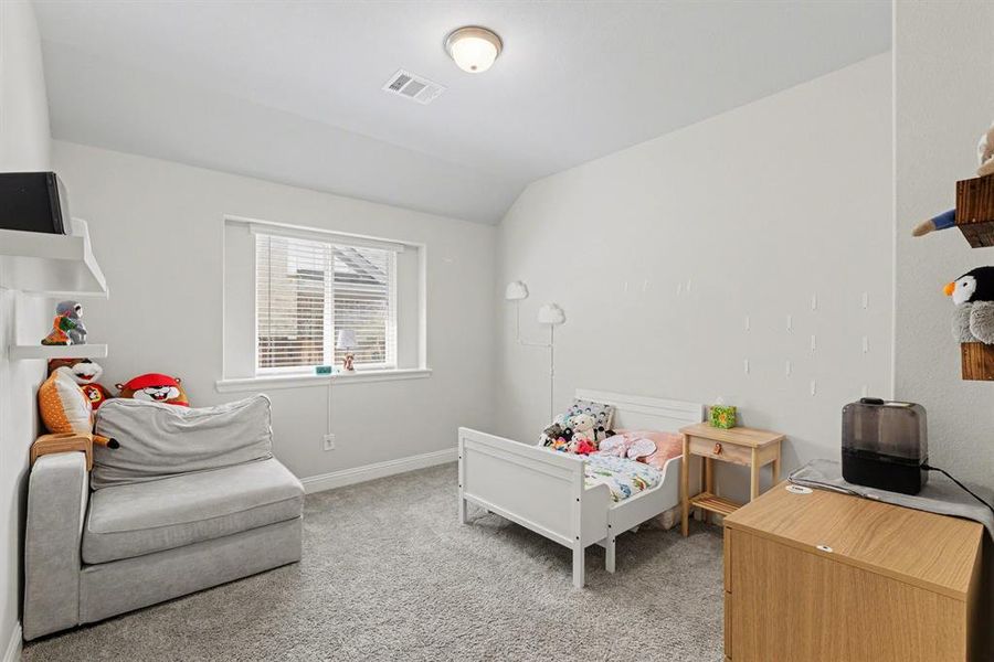 Carpeted room featuring a white-trimmed window with blinds, recessed lighting, and built-in white shelving
