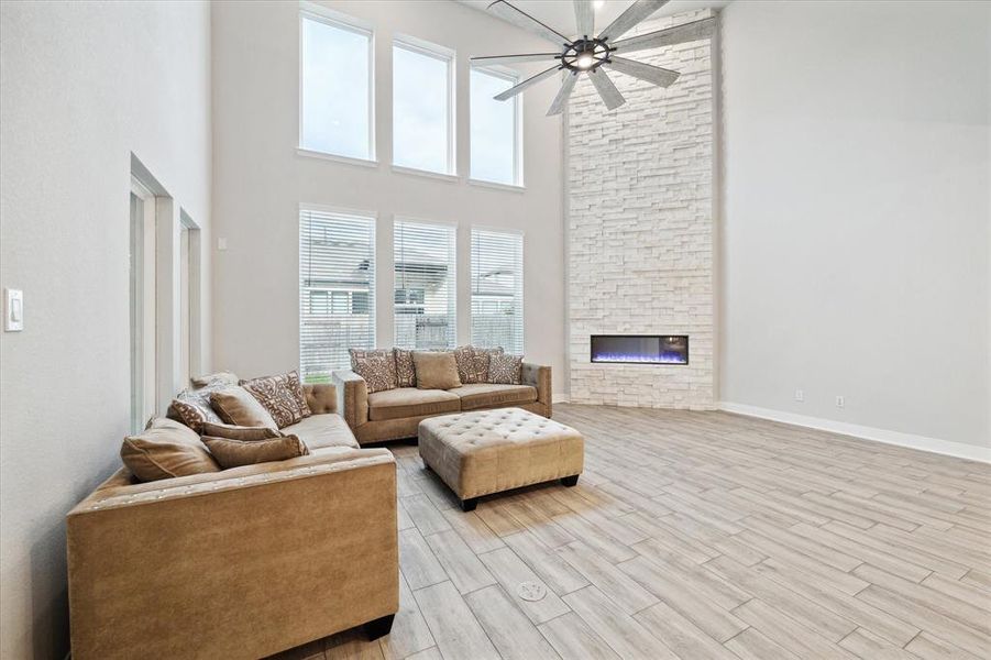 The living room features and upgraded 85"Kilcher Gentry ceiling fan. 55" Scion electric fireplace with Pro Fit Terrain Artic Ledgestone from floor to ceiling.