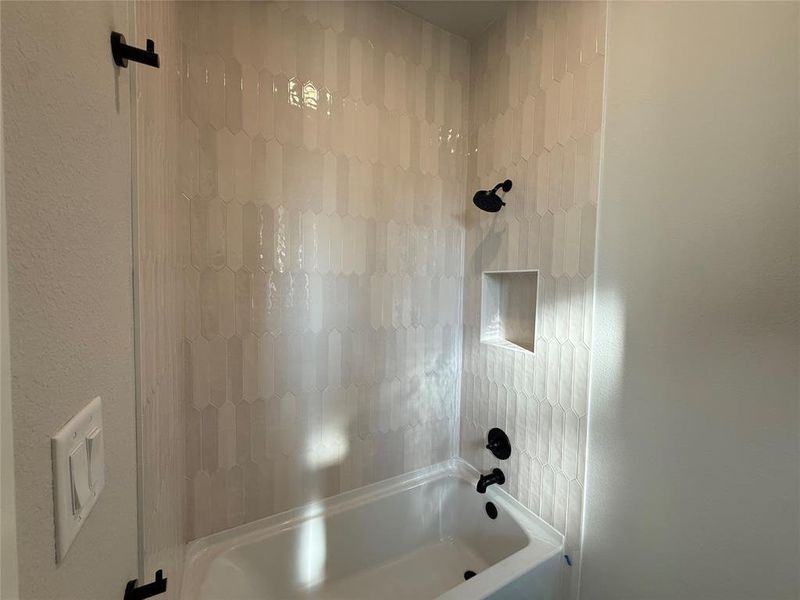 Full bathroom featuring  shower combination and a textured wall