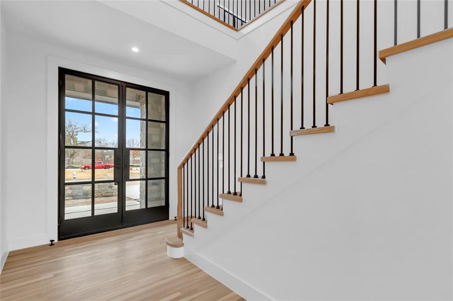 Entryway featuring wood finished floors, recessed lighting, french doors, and a high ceiling Entryway featuring wood finished floors, recessed lighting, french doors, and a high ceiling