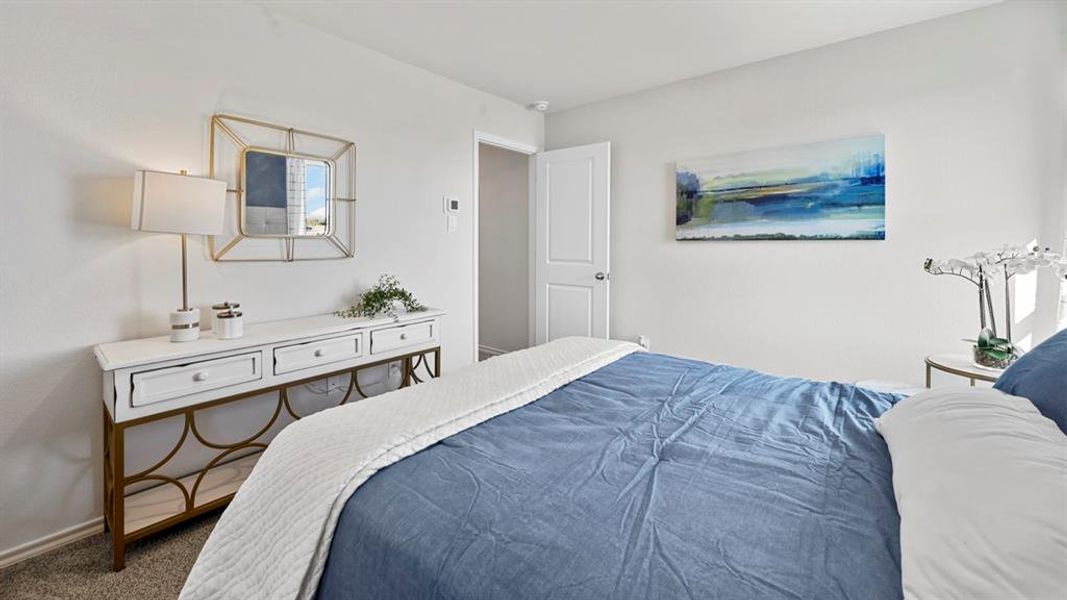 Carpeted room with a white door, light-colored walls, and a decorative mirror
