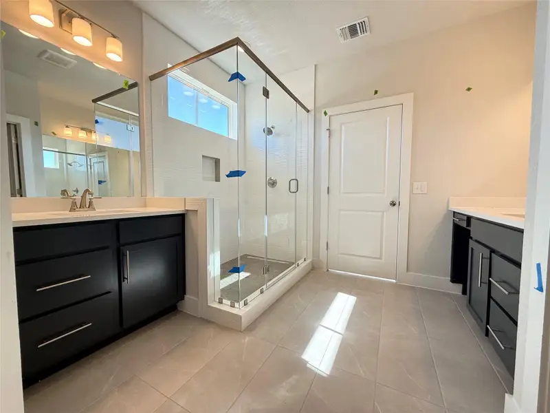 Bathroom with visible vents, baseboards, a stall shower, and vanity
