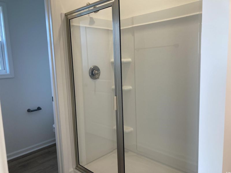 Bathroom featuring light wood-type flooring and a shower stall