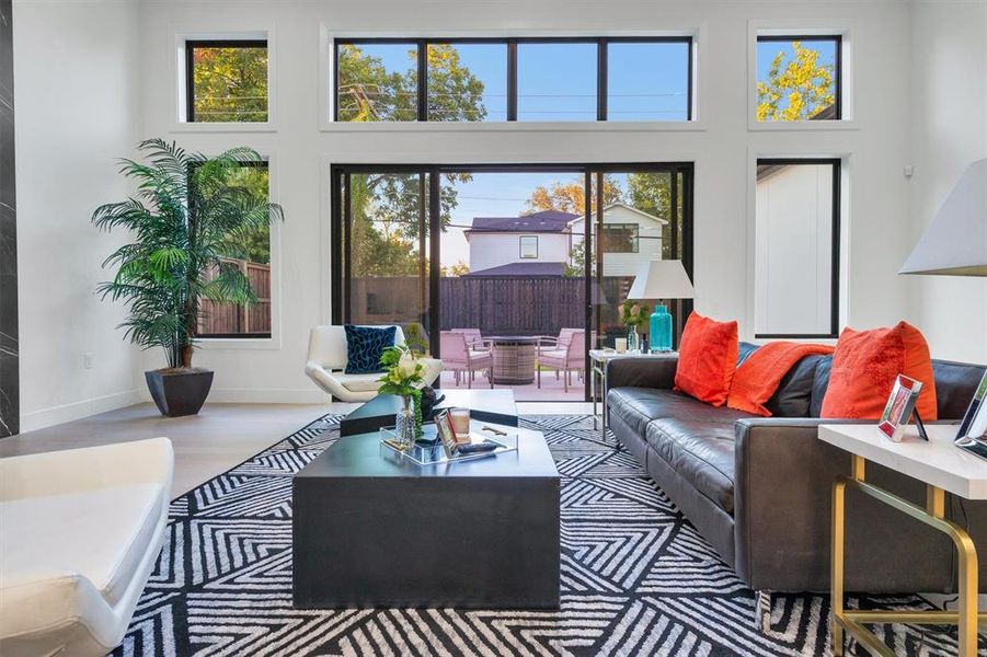 Living room featuring a high ceiling and wood finished floors Living room featuring a high ceiling and wood finished floors