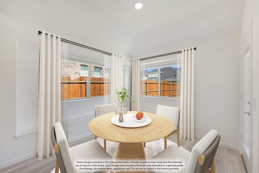 Bright dining area with round wood table, four chairs, and two windows with white curtains Bright dining area with round wood table, four chairs, and two windows with white curtains
