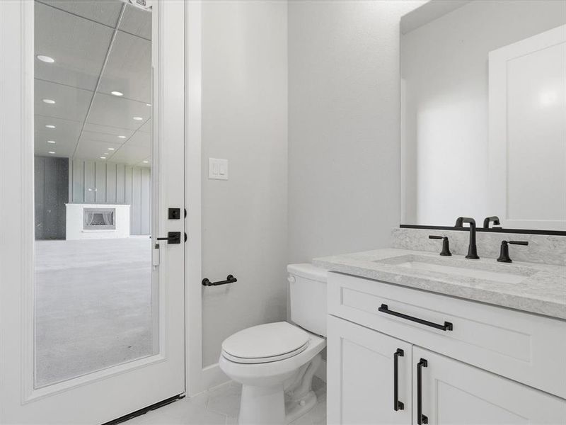 Bathroom featuring a white vanity with black hardware, a light-colored countertop, and a rectangular undermount sink with a matte black faucet