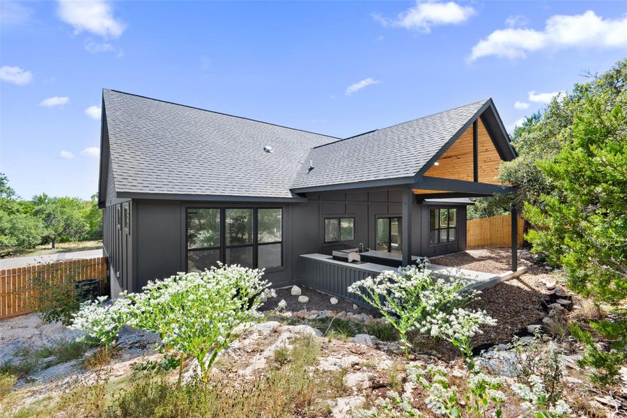 Rear view of property featuring roof with shingles, board and batten siding, and a patio Rear view of property featuring roof with shingles, board and batten siding, and a patio