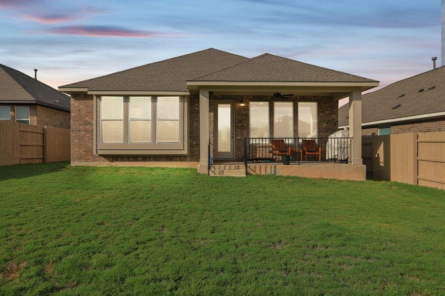 Back of property at dusk featuring Virtual Sunset, brick siding, a ceiling fan, roof with shingles, and a patio area Back of property at dusk featuring Virtual Sunset, brick siding, a ceiling fan, roof with shingles, and a patio area