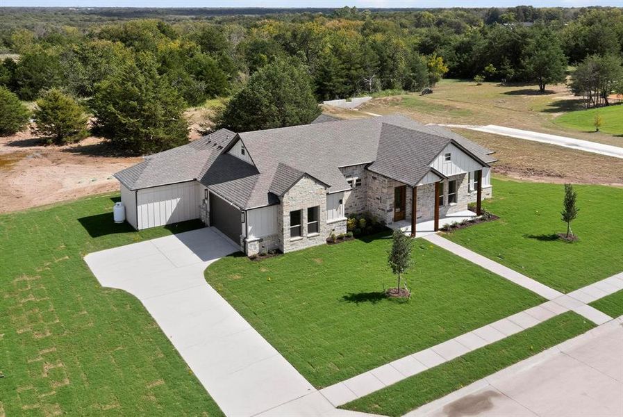 Aerial view of property and surrounding area with a forest