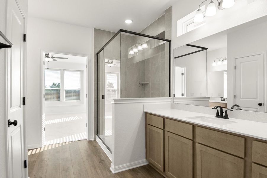 Full bathroom featuring vanity, dark wood-style floors, a stall shower, and ceiling fan