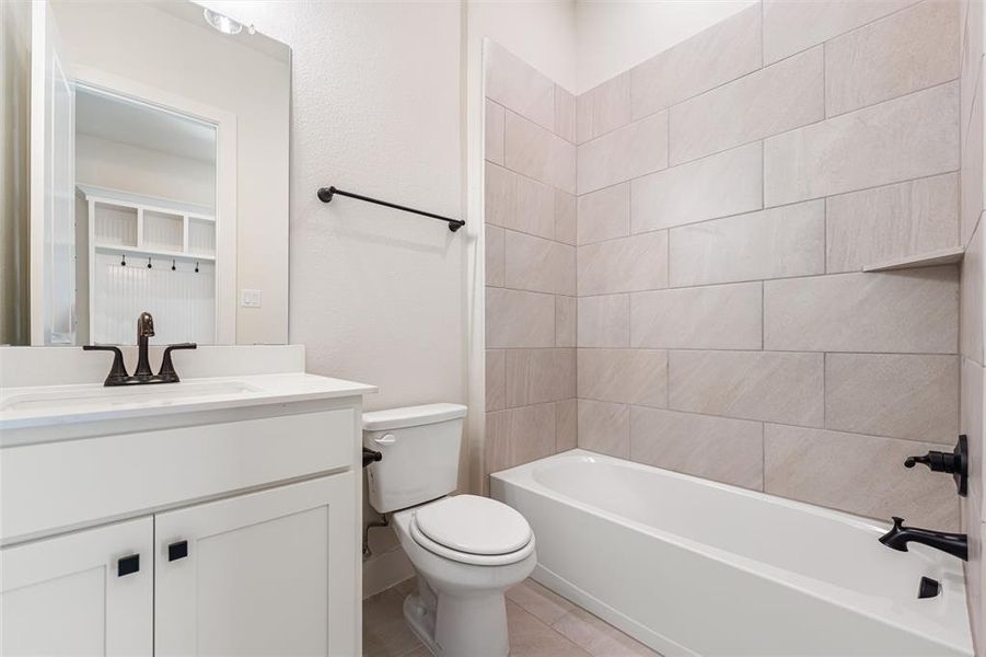 Full bathroom with vanity, shower / bath combination, and light tile patterned floors