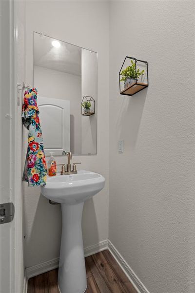 Bathroom featuring dark wood finished floors and a textured wall