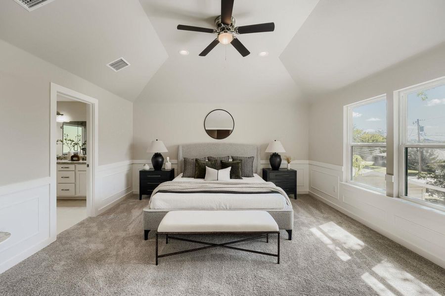 A tranquil primary bedroom with vaulted ceilings, plush carpeting, and a view into the connected primary bath. A tranquil primary bedroom with vaulted ceilings, plush carpeting, and a view into the connected primary bath.