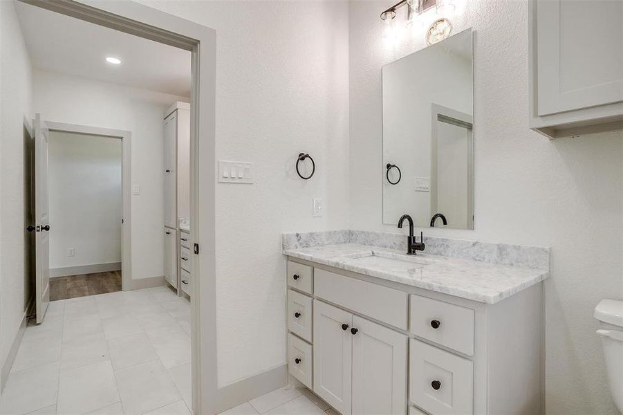 Bathroom featuring tile patterned flooring, toilet, and vanity