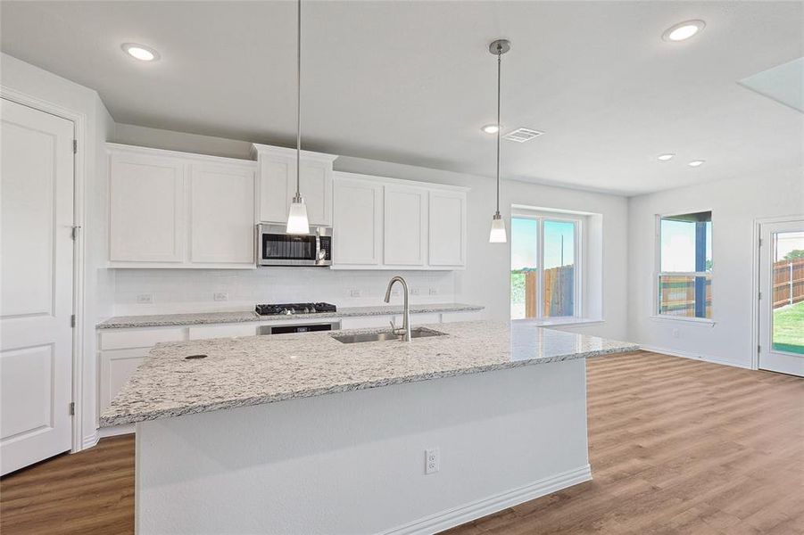 Kitchen featuring a healthy amount of sunlight, white cabinetry, sink, and stainless steel appliances