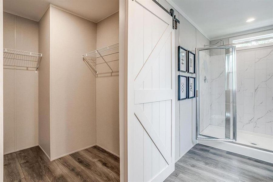 Spacious closet featuring hardwood / wood-style floors and a barn door