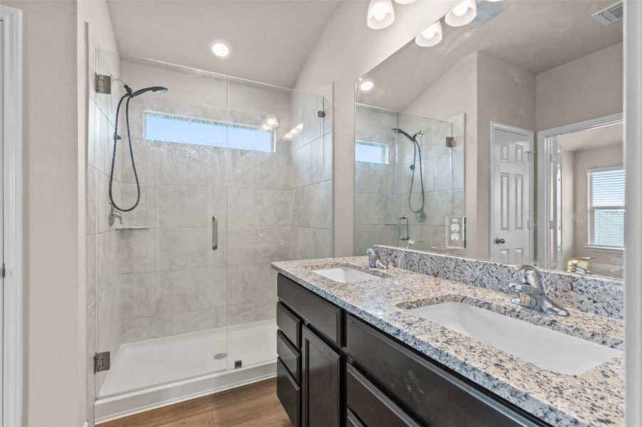 Full bathroom featuring a shower stall, dark wood-style floors, double vanity, and recessed lighting