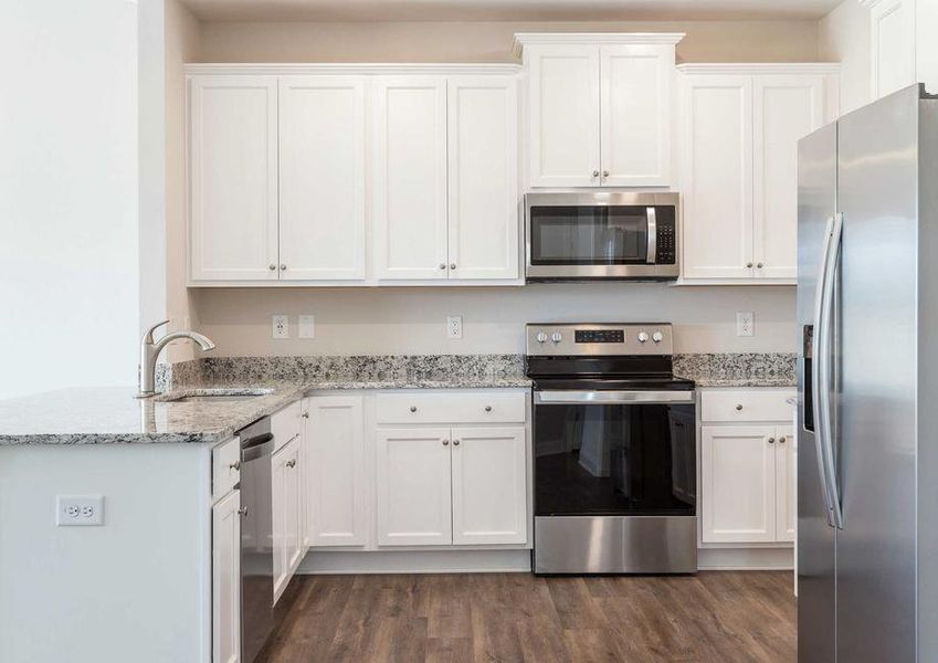 Allatoona kitchen with stainless steel fridge, oven, and microwave on white finish