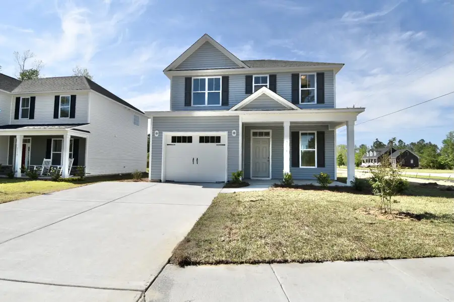 Front exterior of a new home in Patriot’s Watch, Castle Hayne, NC, highlighting curb appeal (Image 1). Front exterior of a new home in Patriot’s Watch, Castle Hayne, NC, highlighting curb appeal (Image 1).