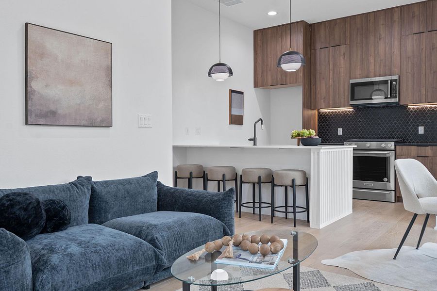 Living area with light wood finished floors and recessed lighting
