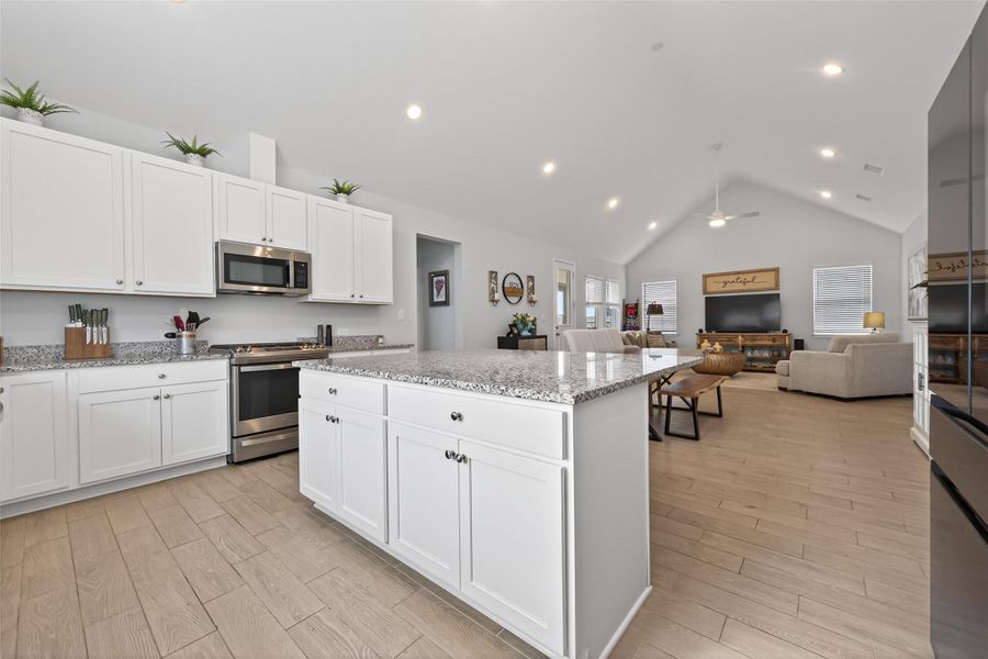 Kitchen with a large center island overlooking the open living and dining areas