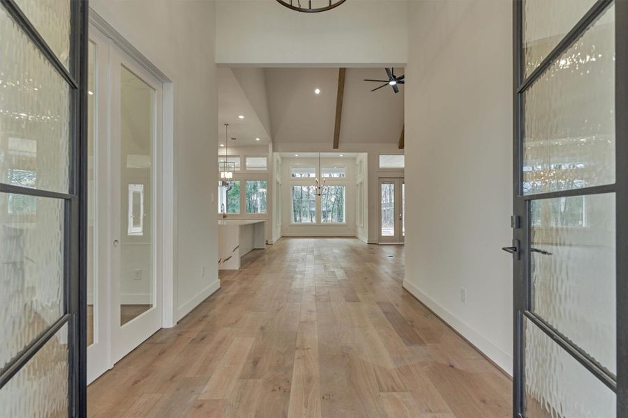 Bright and airy entryway with wide-plank hardwood floors and a stunning view into the open-concept living and kitchen areas.