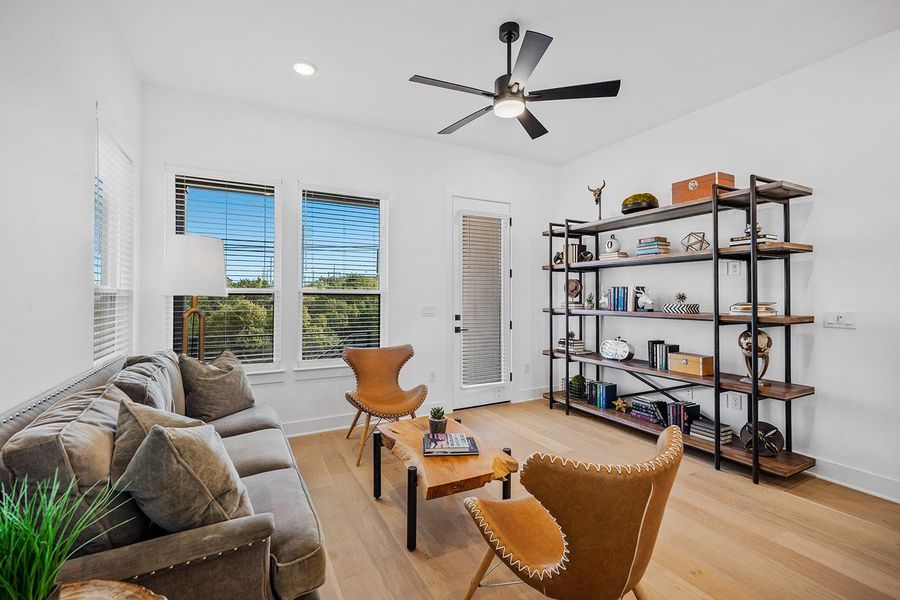 Living room off kitchen and dining room in this open plan with natural light wood flooring.  Big views to the greenbelt and preserve this home backs to.