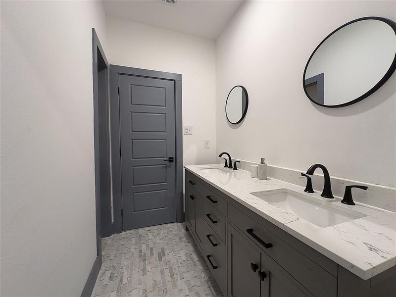 Bathroom with tile patterned floors and double sink vanity