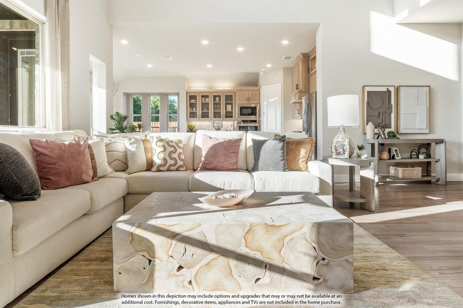 Open living room with large sectional sofa, stone coffee table, and kitchen visible in background Open living room with large sectional sofa, stone coffee table, and kitchen visible in background