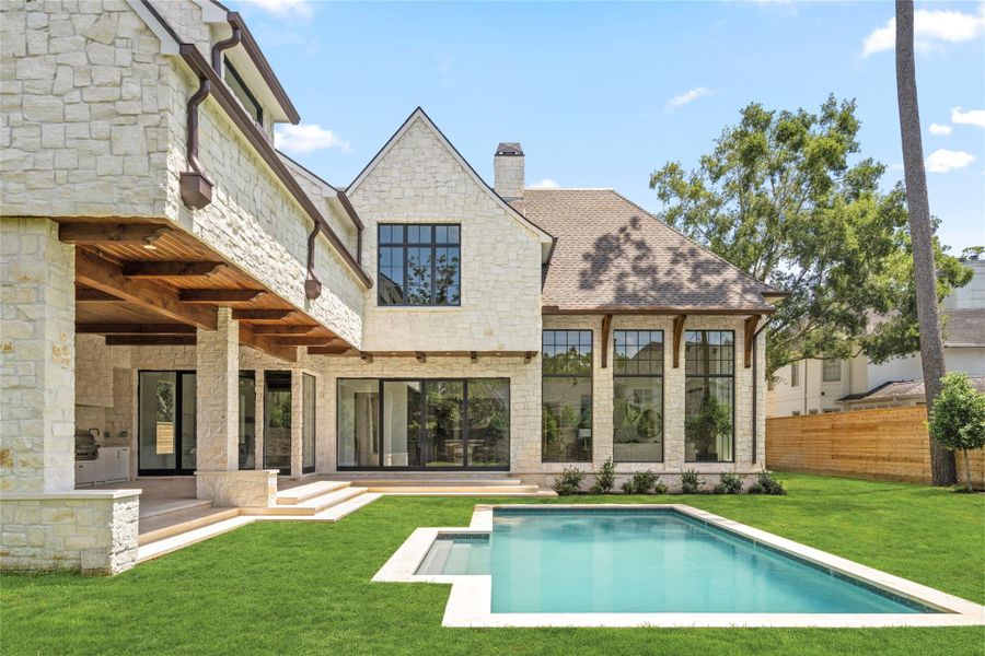 A sparkling pool anchors the expansive backyard, surrounded by generous lawn and thoughtfully designed landscaping. The covered loggia with summer kitchen extends the living space outdoors, while expansive glass doors create an effortless connection to the home’s interiors. A sparkling pool anchors the expansive backyard, surrounded by generous lawn and thoughtfully designed landscaping. The covered loggia with summer kitchen extends the living space outdoors, while expansive glass doors create an effortless connection to the home’s interiors.