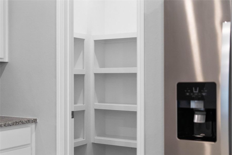 The walk in pantry is well equipped with wooden shelving, keeping every jar and ingredient organized and within easy reach.