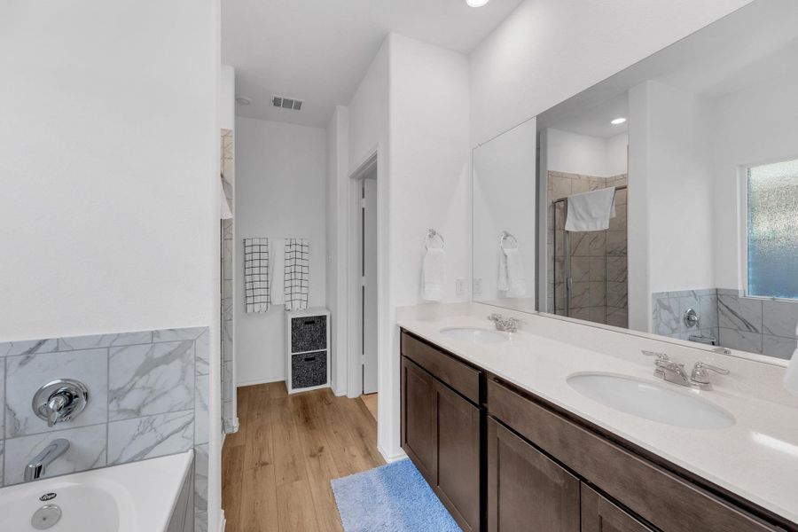 Full bath with a sink, visible vents, a bath, and a stall shower