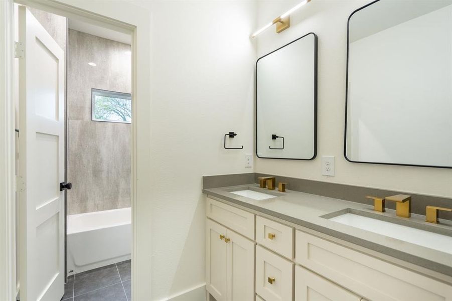 Bathroom featuring vanity, tile patterned floors, and shower / washtub combination