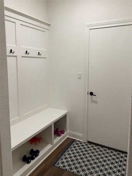 Built-in entryway bench with integrated storage cubbies and wall-mounted coat hooks Built-in entryway bench with integrated storage cubbies and wall-mounted coat hooks