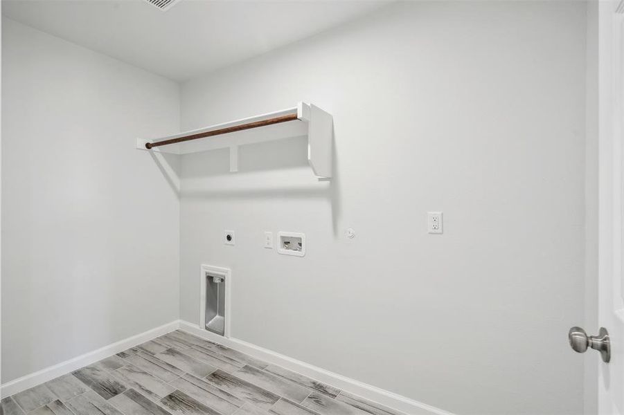 Washroom with gas dryer hookup, hookup for a washing machine, light hardwood / wood-style floors, and hookup for an electric dryer