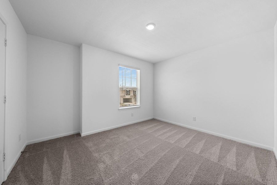 Carpeted spare room featuring baseboards