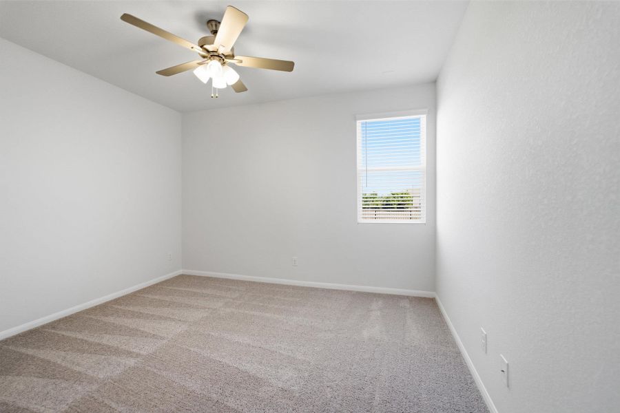 Empty room with light carpet and ceiling fan
