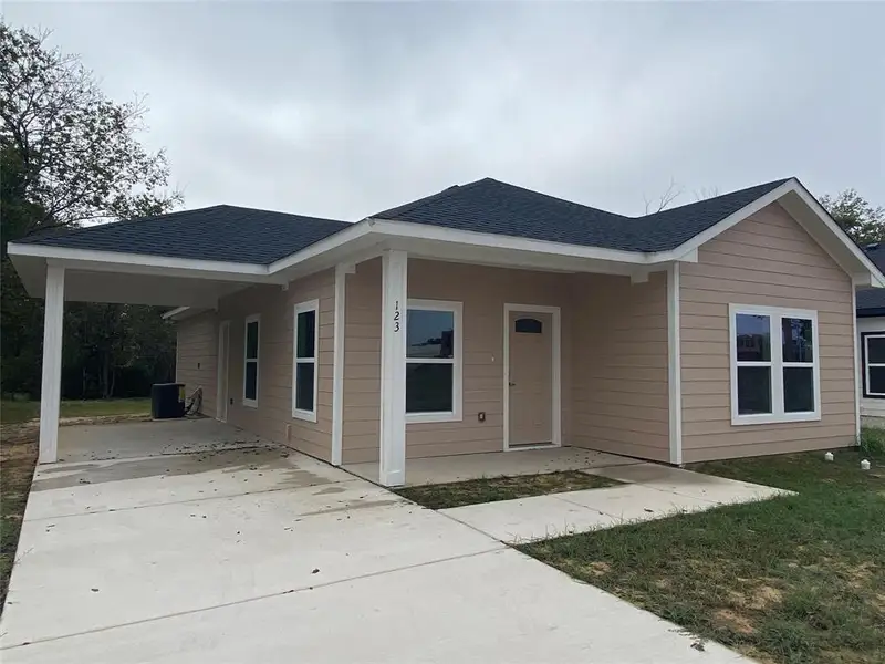 View of front of house with driveway, roof with shingles, an attached carport, a porch, and a front yard View of front of house with driveway, roof with shingles, an attached carport, a porch, and a front yard