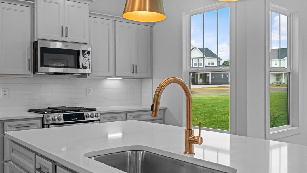 Exclusive DRB Homes kitchen with a 10-foot island, elevated finishes, and pendant lighting in a prime location